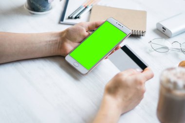 Smartphone ve kredi borç kart kız smartphone yeşil ekran için chroma anahtar elinde. Internet ticaret ve ödemeler için mal ve Hizmetleri Internet üzerinden online alışveriş için