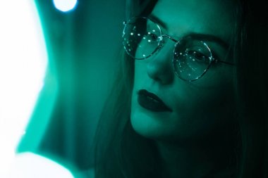 Güzel beyaz kız karanlık ve bokeh Yeşil gözlük bir moda portresi etkisi soluk filmin renkli. Netlik düşük yoğunluklu odak etkisini.