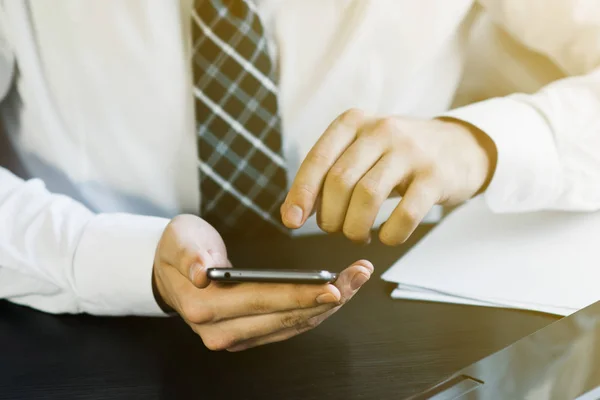 Businessman working with generic design notebook. Holding smartphone in hands. Worldwide connection technology interface