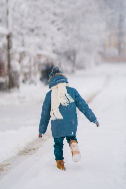 örgü şapka, eldiven ve atkı açık havada kar yağışı, çalışan çocuk. Çocuk kış giysileri içinde