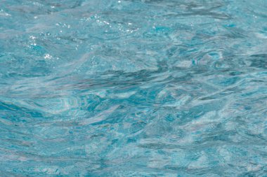 Güneşi yansıtan mavi havuz suyu