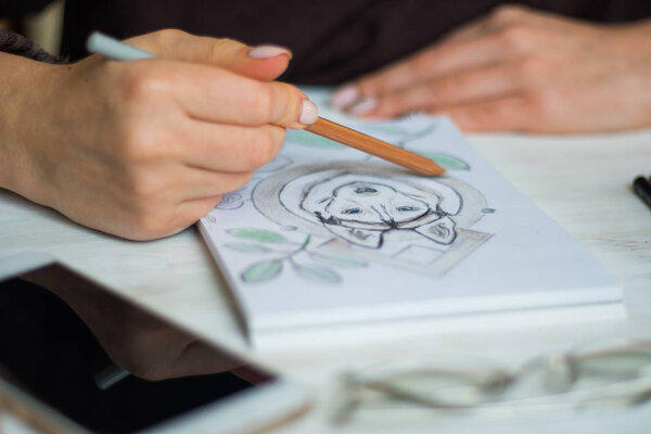 Close up is painting with pencils Husky on a white sheet in a cafe On a white wooden table light background