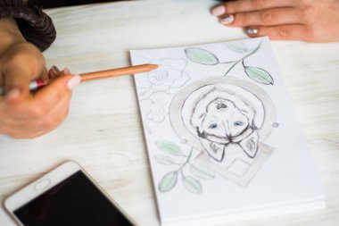 Yakın kadar mı kalemler Husky bir kafede Beyaz ahşap masa ışık arka plan üzerinde beyaz bir kağıda ile boyama