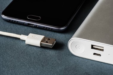 Mobil cihazları şarj etmek için güç bankası. Güç bankası (batarya bankası) olan beyaz akıllı telefon şarjı. Mobil aygıtlar için dış pil.