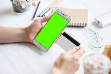 Smartphone ve kredi borç kart kız smartphone yeşil ekran için chroma anahtar elinde. Internet ticaret ve ödemeler için mal ve Hizmetleri Internet üzerinden online alışveriş için