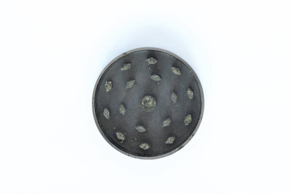 Metallic gray part of grinder for buds of marijuana isolated on white background