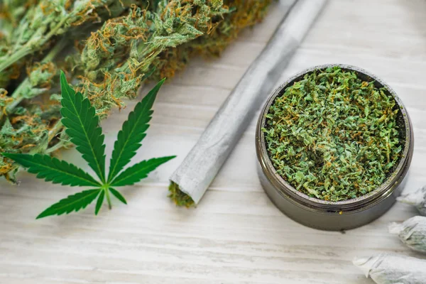 Joint und eine Mühle mit zerkleinertem Unkrautblatt von Cannabis, Knospen von Marihuana, Unkraut auf weißem Hintergrund — Stockfoto