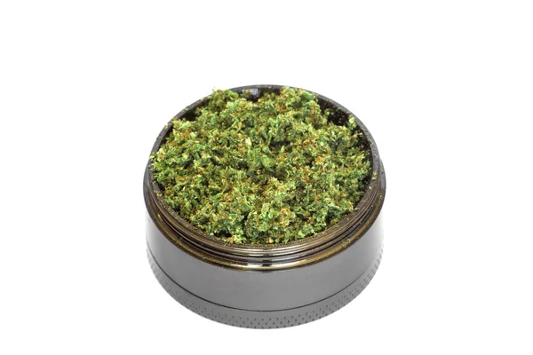 Grinder met Crushed toppen van marihuana, onkruid cannabis geïsoleerd op witte achtergrond — Stockfoto