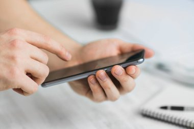 Adam Hipster smartphone kafe eller bir dokunmatik ekran akıllı telefon kapatmak, vintage renkleri kullanarak