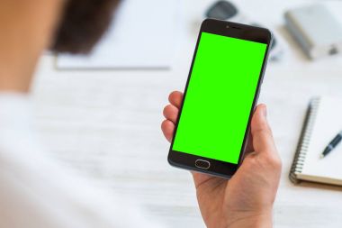 Siyah bir smartphone ile yeşil ekran chroma anahtar birleştirme için Internet ticaret ve ödemek için online banka ve Internet, üstten görünüm malların kullanımı beyaz arka plan üzerinde bir adam elinde.