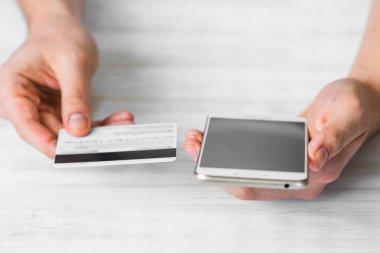 Siyah bir smartphone ve kırsal beyaz arka plan, Internet ticaret kavramları ve online bankacılık kullanımı hizmet için ödemek bir adam elinde bir kredi kartı ve internet ürünler