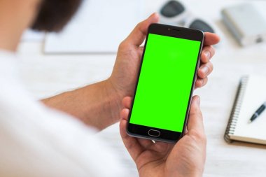 Adam bir akıllı telefon ile yeşil ekran chroma anahtar birleştirme için kullanır. Mobil cihazlar, mobil versiyonu sitedeki demolar kullanımının kavramları