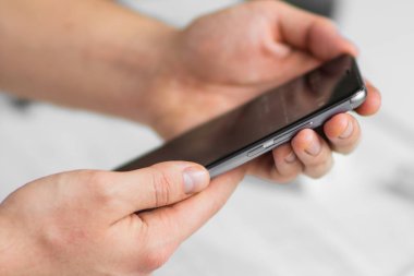 Smartphone bir dokunmatik ekran akıllı telefon ellerini yakın, vintage renkler kullanan adam