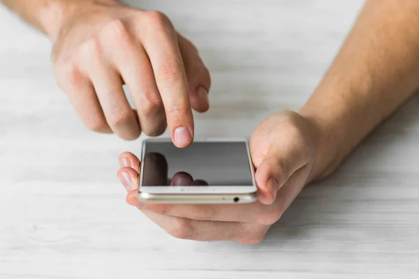 Hombre usando el teléfono inteligente una pantalla táctil manos del teléfono inteligente de cerca, colores vintage — Foto de Stock