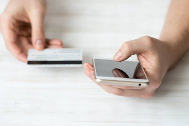 akıllı telefon ve hizmet için ödemek bir adam beyaz bir arka plan, Internet ticaret kavramları ve online bankacılık kullanımı elinde kredi kartı ve Ürünler internet, üstten görünüm.