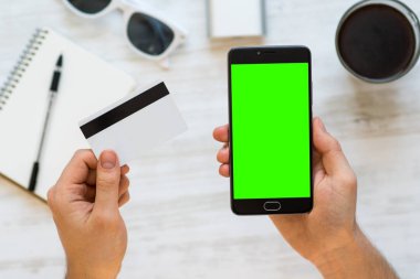 Hizmetler ve Ürünler internet ödemek için chroma anahtar kompozisyon ve beyaz arka plan, Internet ticareti online bir adam elinde bir kredi kartı için yeşil ekran ile akıllı telefon bankacılığı