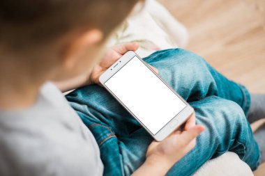 Çocuk çocuk bir telefon ile a beyaz perde için sahte elinde tutuyor