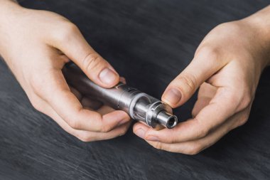 Adam el buharı arka plan bulut vape aygıtı gösterir. Vape kavramı, tonda