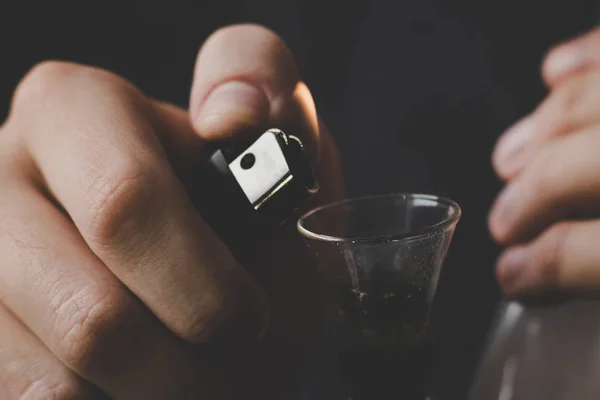 Koncepce užívání lékařské marihuany a legalizace konopí. Muž kouří konopí plevel, bong a zapalovač ve svých rukou. Kouř na černém pozadí. — Stock fotografie