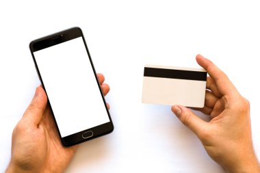 el kredi kartı tutan ve smartphone A siyah smartphone sahte kullanarak ve bir kredi kartı Closeup elinde işadamı fotoğraf. Online ödeme plastik kart. Yatay mockup. Bulanık, film etkisi