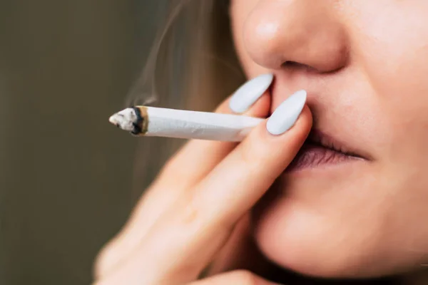 Eine Frau raucht Cannabiskraut, einen Joint und ein Feuerzeug in seinen Händen. Rauch auf schwarzem Hintergrund. Konzepte des medizinischen Marihuana-Konsums und der Legalisierung von Cannabis. — Stockfoto