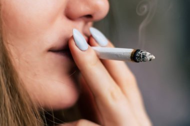 Bir kadın sigara esrar esrar, esrar ve onun elinde bir çakmak. Siyah bir arka plan üzerinde duman. Tıbbi esrar kullanım ve yasallaştırma esrar kavramları.