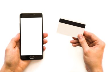 Siyah smartphone kadar alay etmek ve bir kredi kartı Closeup elinde tutarak el kredi kartı ve smartphone kullanarak işadamı fotoğraf. Online ödeme plastik kart. Yatay mockup. Bulanık, film etkisi