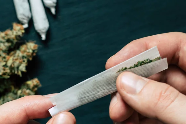 Tidak sepenuhnya digulung jamb bersama di tangan seorang pria ganja gulma konsep mariyuana legalisasi dan penggunaan ganja untuk tujuan medis — Stok Foto