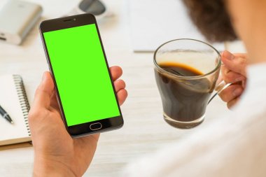 Siyah smartphone için chroma anahtar adam yeşil ekran ile bir akıllı telefon ile yeşil ekran için chroma anahtar Yarışması kompozisyon Online ödeme plastik kart kullanır tutan el