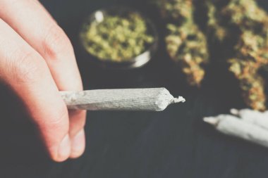 Paspas vintage renge karşı bir adam elinde esrar ile ortak haddelenmiş