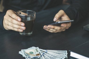 Teknoloji, online bankacılık, para transferi, e-ticaret kavramı. Kullanma smartphone dolarlarına gri duvar arka plan üzerinde uçan iş adamı. Internet kazanç kavramı
