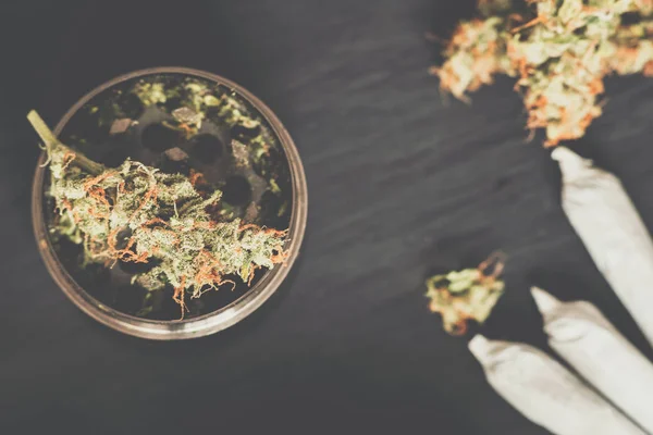 Moedor para cortar maconha e uma flor de maconha em Matting cor do vintage — Fotografia de Stock