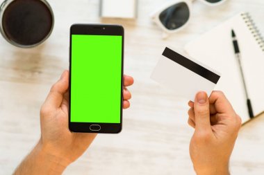 Chroma anahtar kompozisyon Online ödeme plastik kart. chroma anahtar kompozisyon ve siyah smartphone ile yeşil perde için tutan bir el için yeşil ekran ile Smartphone