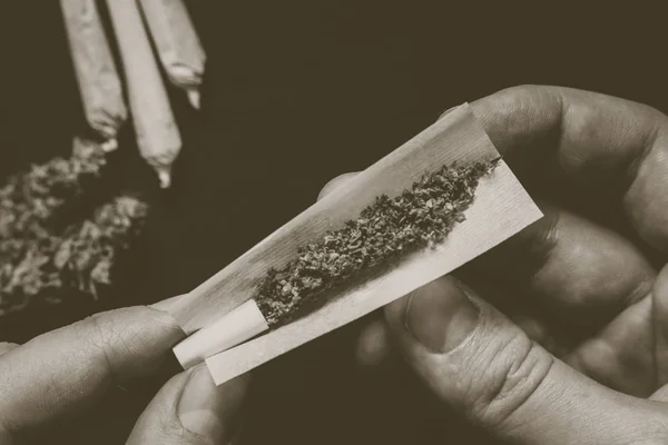 Not fully rolled jamb joint in the hands of a man marijuana weed Vintage color — Stock Photo, Image