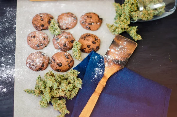 Cookie-kat, a kannabisz és a rügyek, a marihuána, az asztalon. Főzés a kannabisznövény fogalmának. Kezelés orvosi felülnézet marihuána használata az élelmiszer-, a fekete háttér — Stock Fotó