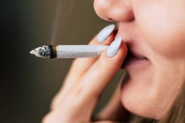 Esrar ot, onun eller A kadın ortak bir çekiyor. Siyah bir arka plan üzerinde duman. Tıbbi esrar kullanım ve yasallaştırma esrar kavramları.