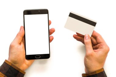yukarı alay ve bir kredi kartı Closeup A elinde siyah el kredi kartı tutan ve smartphone kullanarak smartphone fotoğraf işadamı. Online ödeme plastik kart. Yatay mockup. Bulanık, film