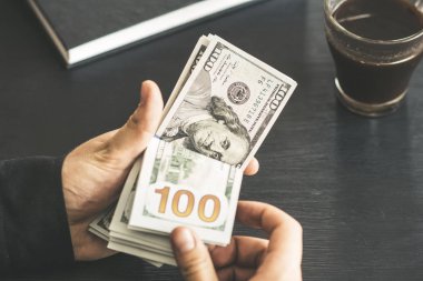 tekrar sayım dolar ver. adam parayı sayar. yeni yüz dolarlık banknot. Yeni Finans teknolojileri ve iş haberleri kavramları. Yatay