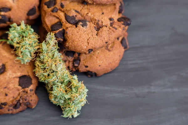 Biscoitos com maconha e botões de maconha na mesa. Copiar espaço Conceito de cozinhar com erva de cannabis. vista superior Tratamento de maconha medicinal para uso em alimentos, Em um fundo preto — Fotografia de Stock