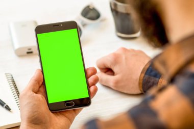 El ile yeşil perde chroma anahtar kompozisyon siyah bir smartphone için chroma anahtar kompozisyon Online ödeme plastik kart için yeşil ekran ile siyah smartphone tutarak