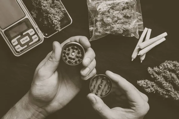 Slipmaskin för cannabis slipning i händerna på en man mot Vintage färg — Stockfoto