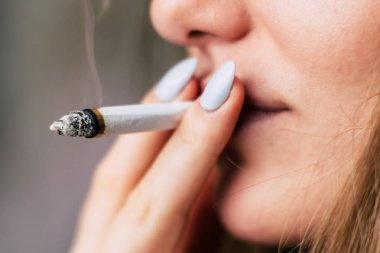 Bir kadın sigara ot esrar esrar ve onun elinde bir çakmak. Siyah bir arka plan üzerinde duman. Tıbbi esrar kullanım ve yasallaştırma esrar kavramları.