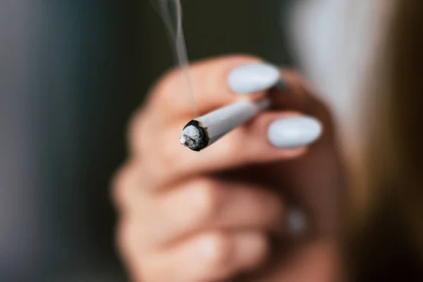 Una donna fuma erba di cannabis, una canna e un accendino nelle sue mani. Fumo su fondo nero. Concetti di uso medico di marijuana e legalizzazione della cannabis . — Foto Stock
