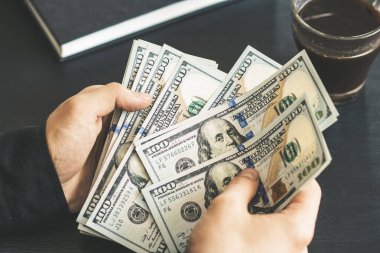 Dolarları elle saymak. Adam parayı sayıyor. yeni yüz dolarlık banknotlar