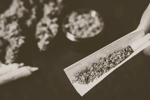 Niet volledig portierstijl joint gerold in de handen van een man marihuana onkruid Vintage kleur — Stockfoto