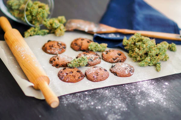 Kekse mit Cannabis und Knospen Marihuana auf dem Tisch. Konzept des Kochens mit Cannabiskraut. Behandlung von medizinischem Marihuana zum Verzehr in Lebensmitteln, Auf schwarzem Hintergrund — Stockfoto