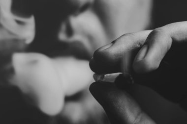 Bir adam sigara esrar esrar, esrar ve çakmak elinde. Siyah bir arka plan üzerinde duman. Tıbbi esrar kullanım ve yasallaştırma esrar kavramları. Siyah ve beyaz