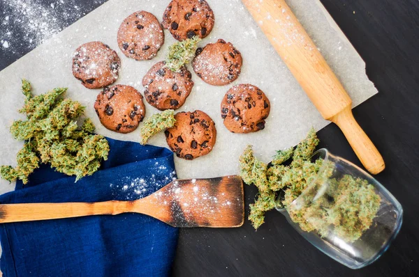 Cookie-kat, a kannabisz és a rügyek, a marihuána, az asztalon. felső viewconcept a főzés a kannabisznövény. Kezelés orvosi marihuána használható, a fekete háttér-felülnézet — Stock Fotó