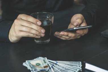 Teknoloji, online bankacılık, para transferi, e-ticaret kavramı. Kullanma smartphone dolarlarına gri duvar arka plan üzerinde uçan iş adamı. Internet kazanç kavramı