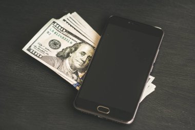 Smartphone bir siyah kalem, kitap ve kulaklık, yeni Finans teknolojileri ve iş haberleri kavramlarını ahşap masa dokulu. Yatay